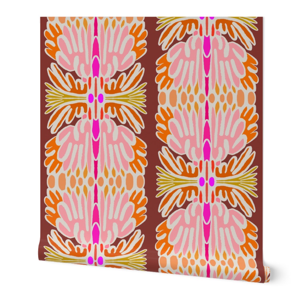 Wallpaper featuring a bold retro mid-century modern pattern with pink, orange, yellow, and white motifs on a dark brown background, shown against a plain white studio backdrop. Designed by artist Leila Simon Hayes.