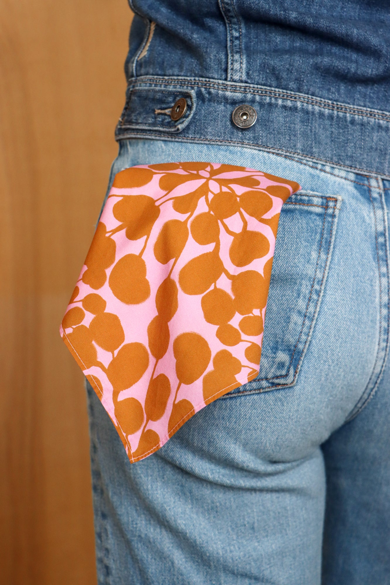 Person wearing a pink and brown patterned cloth over their back pocket. Designed by artist Leila Simon Hayes.