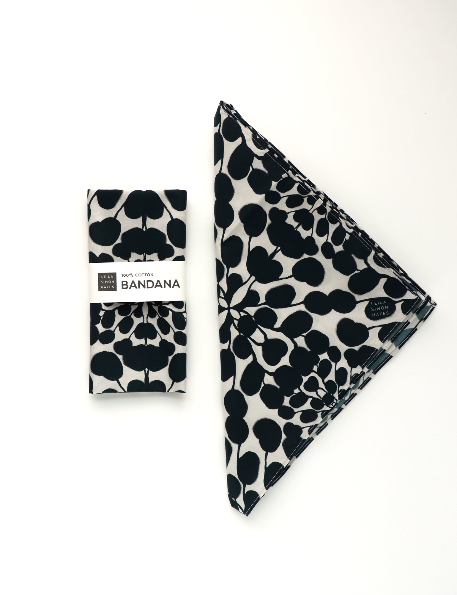 Black and white patterned bandana with packaging on a white background. Designed by artist Leila Simon Hayes.