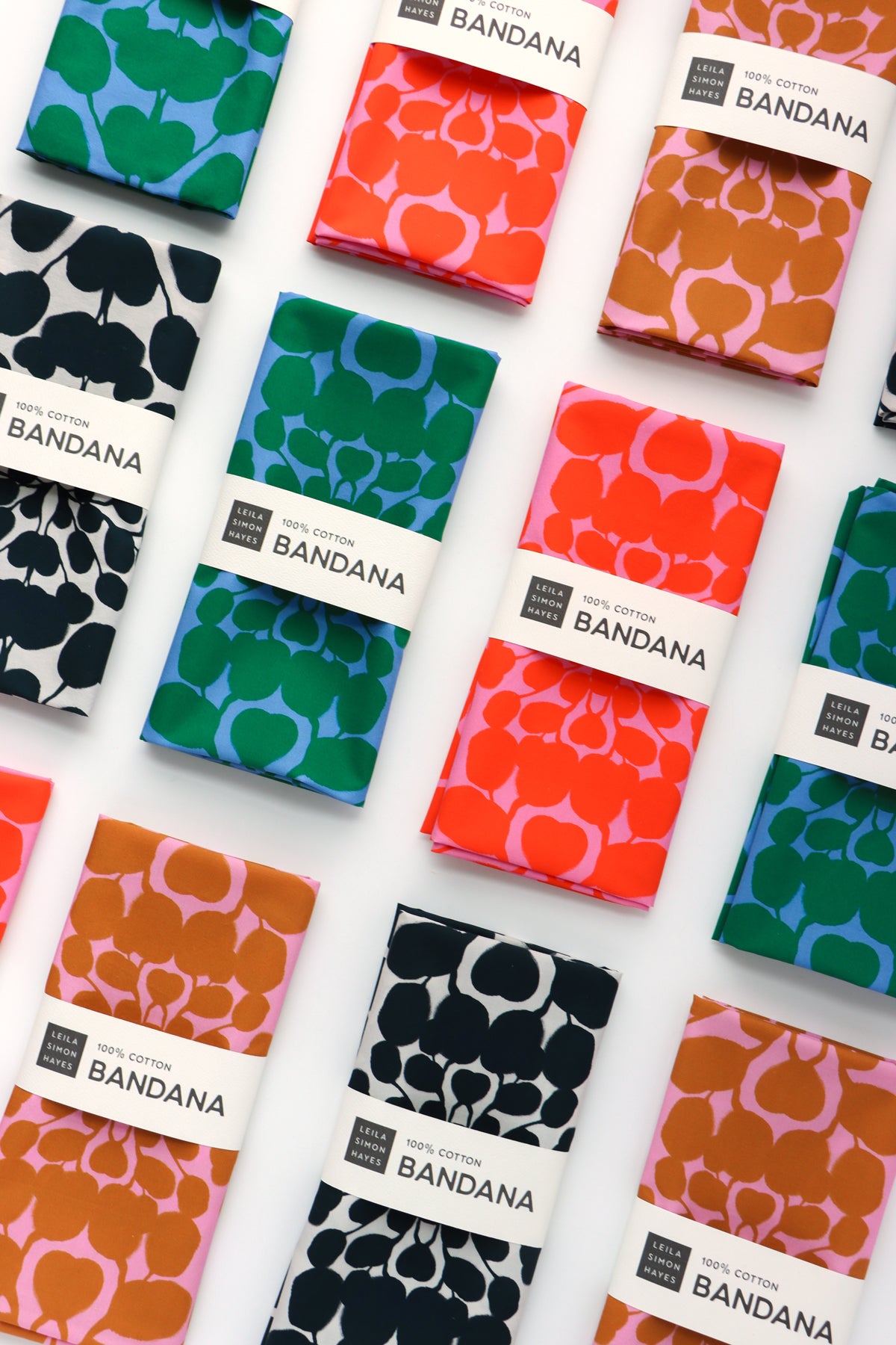Collection of colorful bandanas with various patterns on a white background. Designed by artist Leila Simon Hayes.