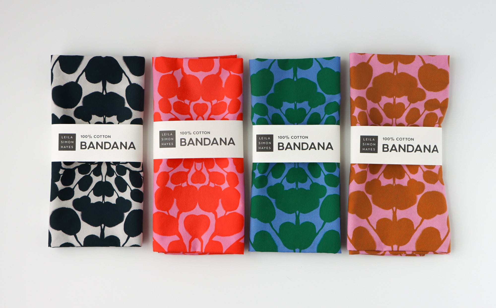 Four bandanas with different patterns and colors on a white background. Designed by artist Leila Simon Hayes.