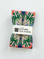 Kitchen tea towel with colorful floral pattern and label saying "100% Linen" on a white background. Designed by artist Leila Simon Hayes.