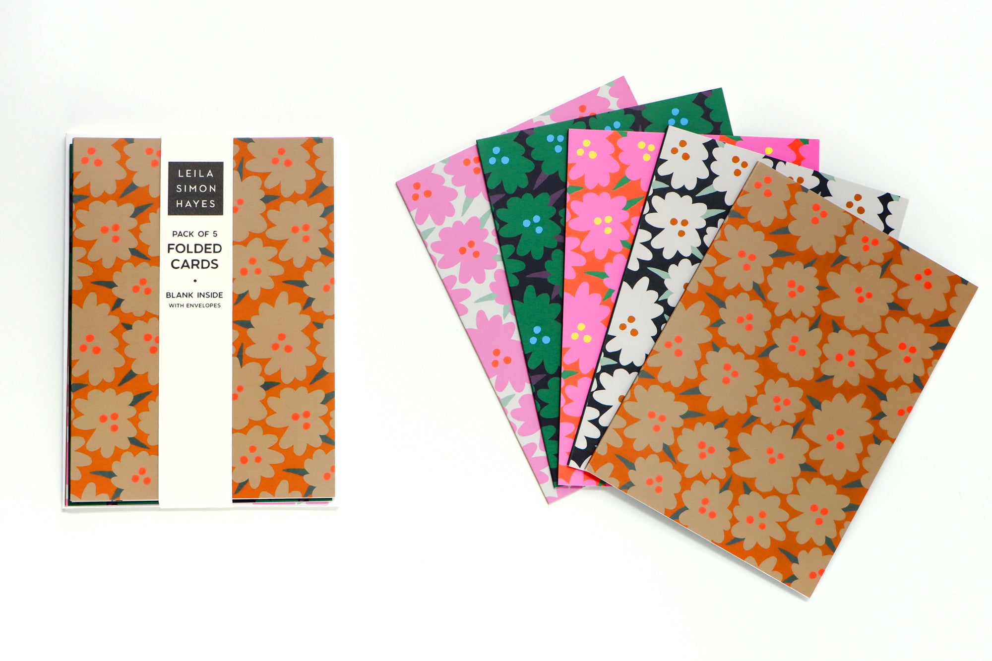 Pack of five abstract floral folded cards packaged and spread out in different colors on a white background. Designed by artist Leila Simon Hayes.