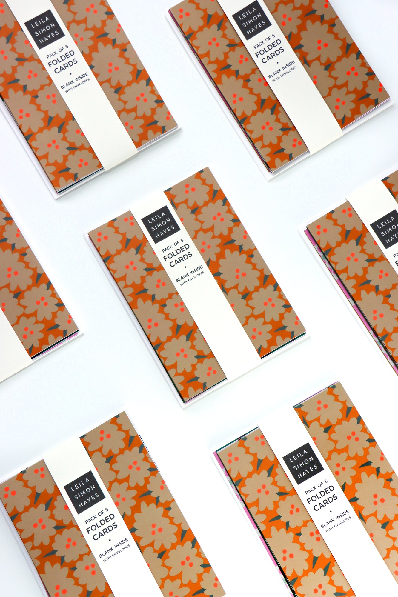 Pack of five abstract floral folded cards packaged and spread out on a white background. Designed by artist Leila Simon Hayes.