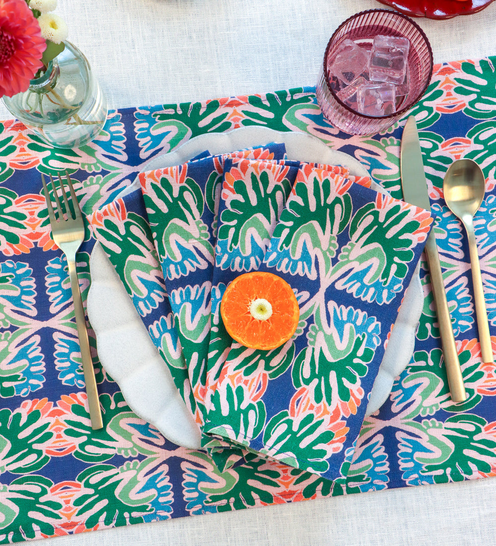 Designed by artist Leila Simon Hayes. Table setting with hand drawn flourish designed dinner napkins on a placemat.