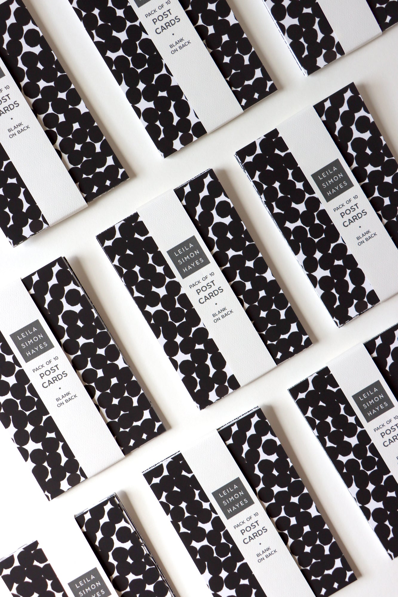 Pack of 10 black and white postcards packaged with a label on a white background. Designed by artist Leila Simon Hayes.