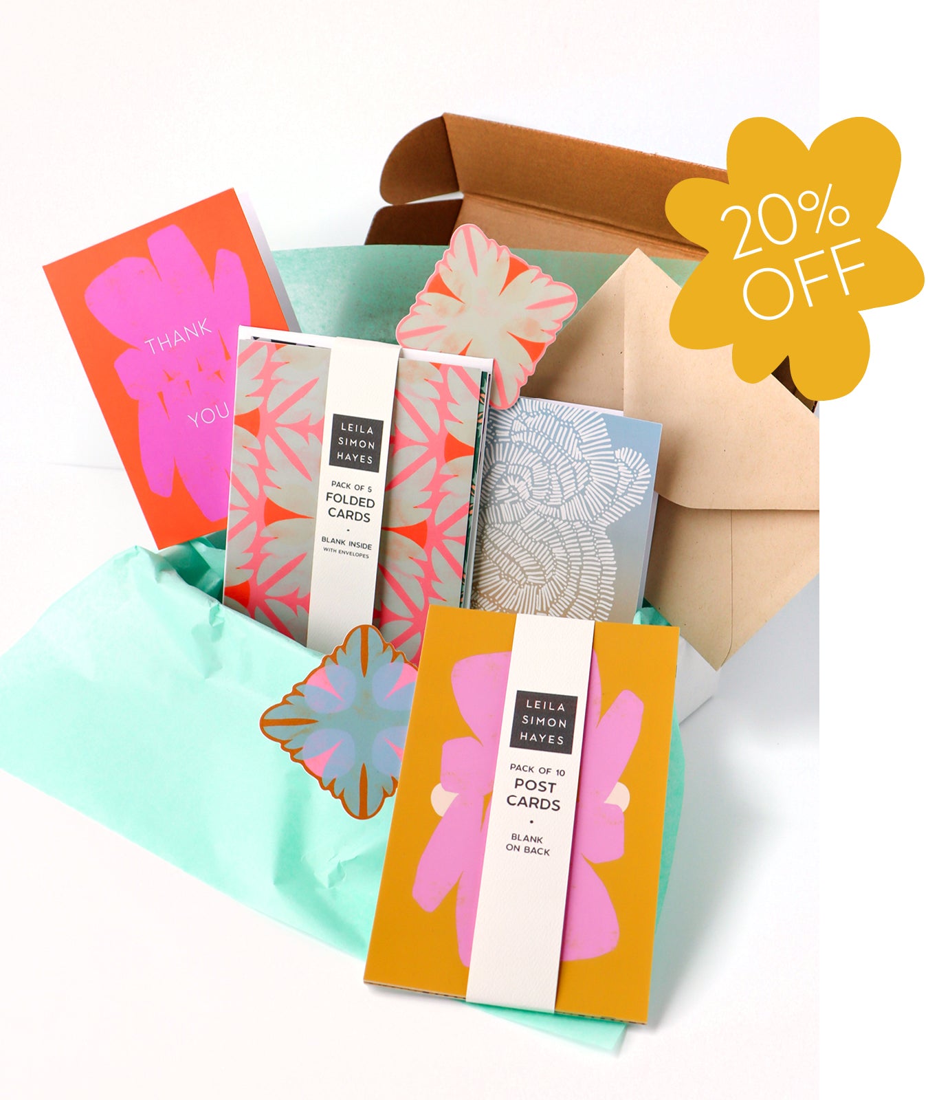 Collection of colorful stationery, designed by artist Leila Simon Hayes. Items including postcards and envelopes with a discount label for 20% off. 