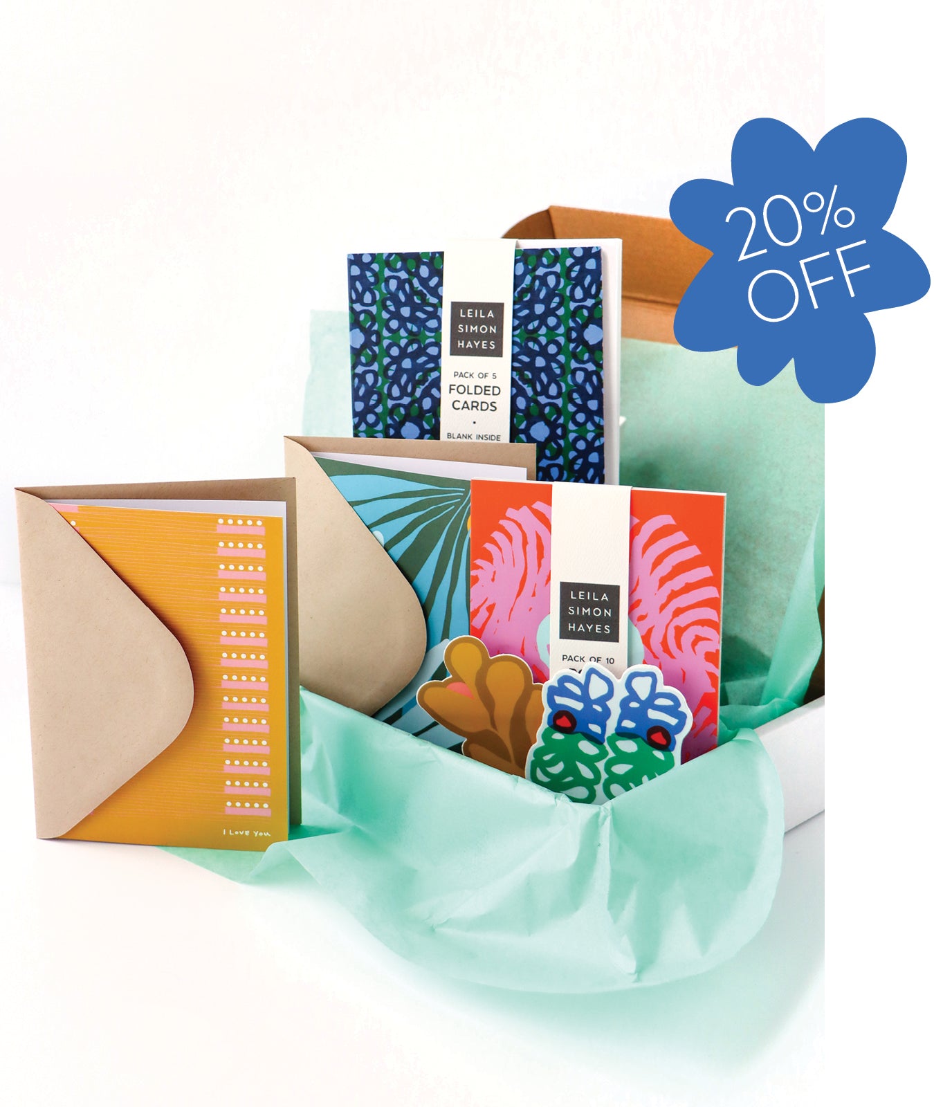 Collection of colorful stationery, designed by artist Leila Simon Hayes. Items including postcards and envelopes with a discount label for 20% off. 