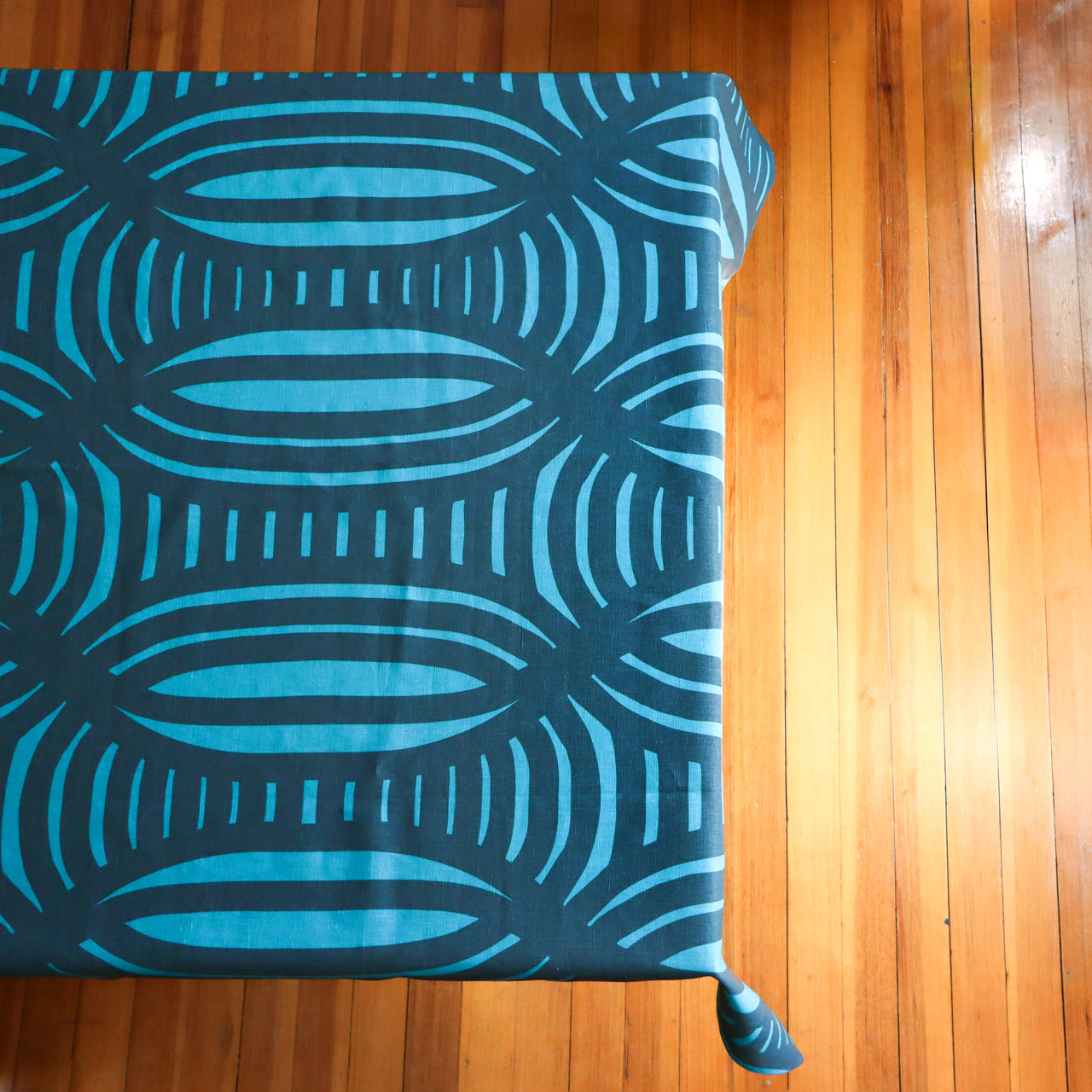 Navy blue and light blue table cloth with a geometric stripe pattern on a table. Designed by artist Leila Simon Hayes.