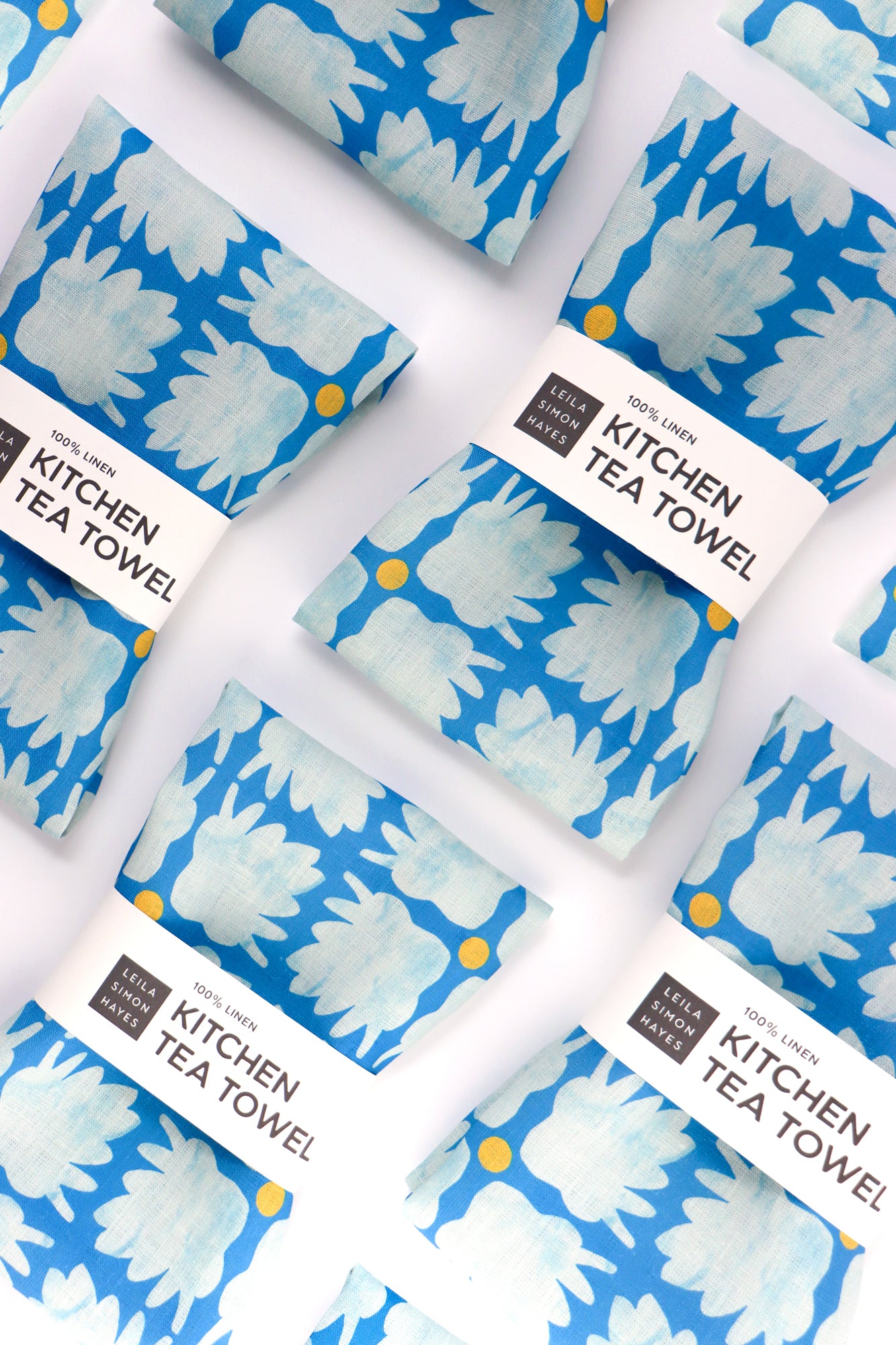 Kitchen tea towels with blue floral design on a white background. Designed by artist Leila Simon Hayes.
