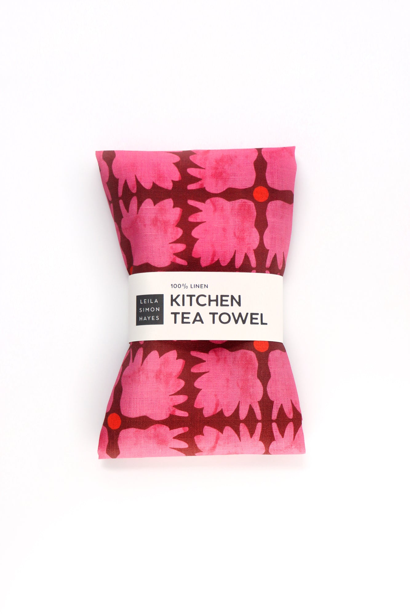 Kitchen tea towel with pink floral pattern on a white background. Designed by artist Leila Simon Hayes.