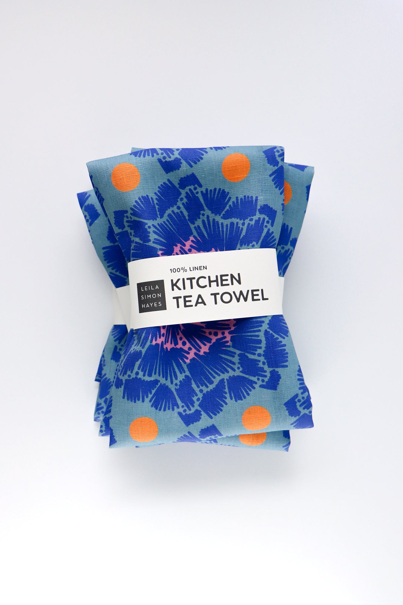 Set of blue floral kitchen tea towels with orange dots on a white background. Designed by artist Leila Simon Hayes.