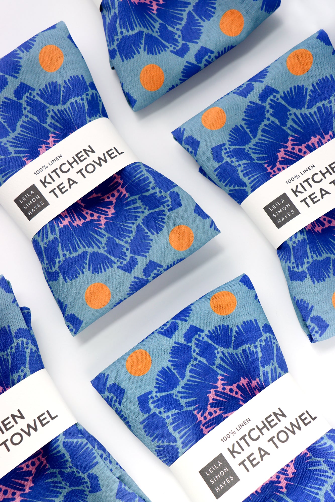 Set of blue kitchen tea towels with orange dots on a white background. Designed by artist Leila Simon Hayes.