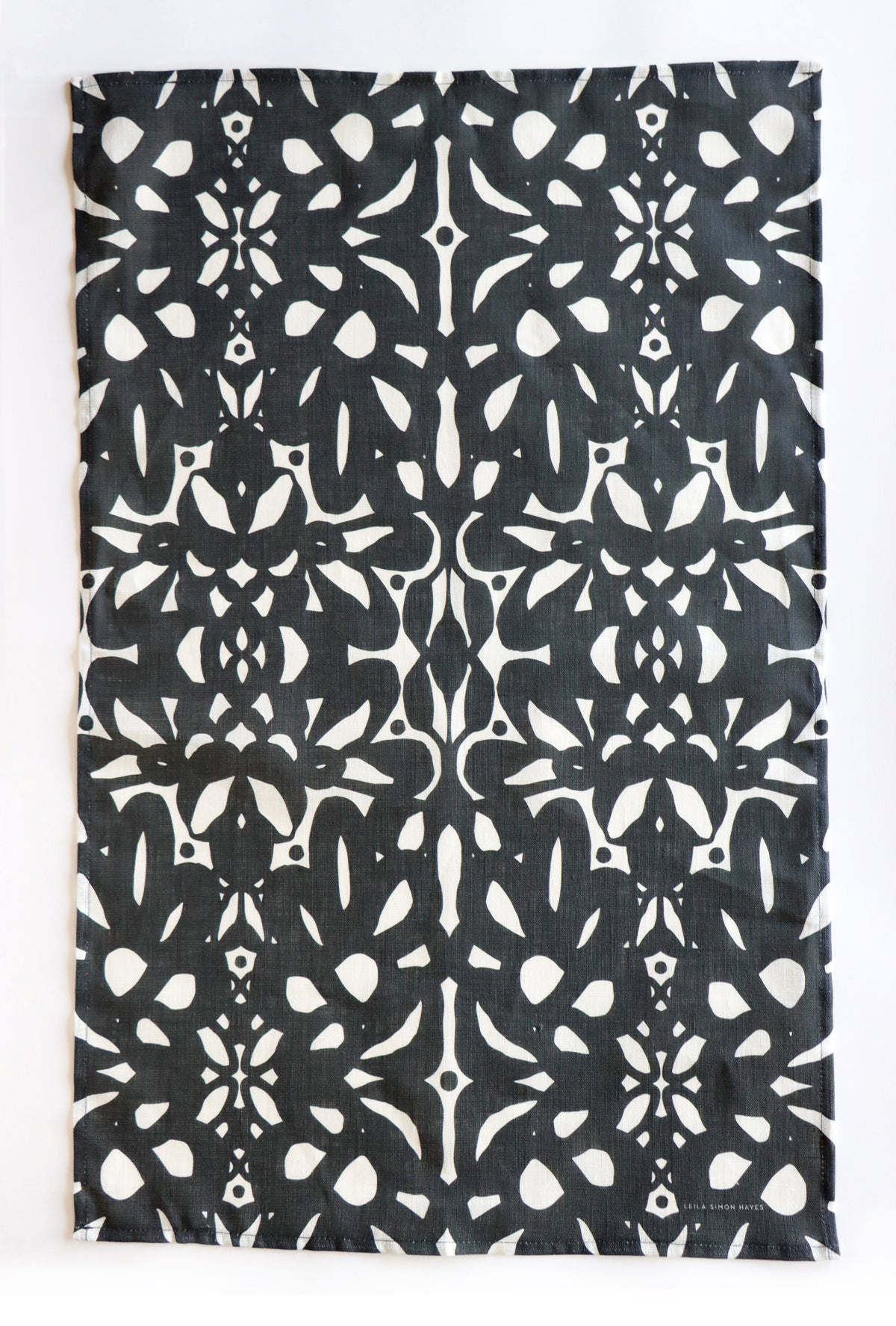 Black and white patterned tea towel on a white background. Designed by artist Leila Simon Hayes.