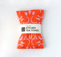 Orange kitchen tea towel with pink pattern on a white background. Designed by artist Leila Simon Hayes.