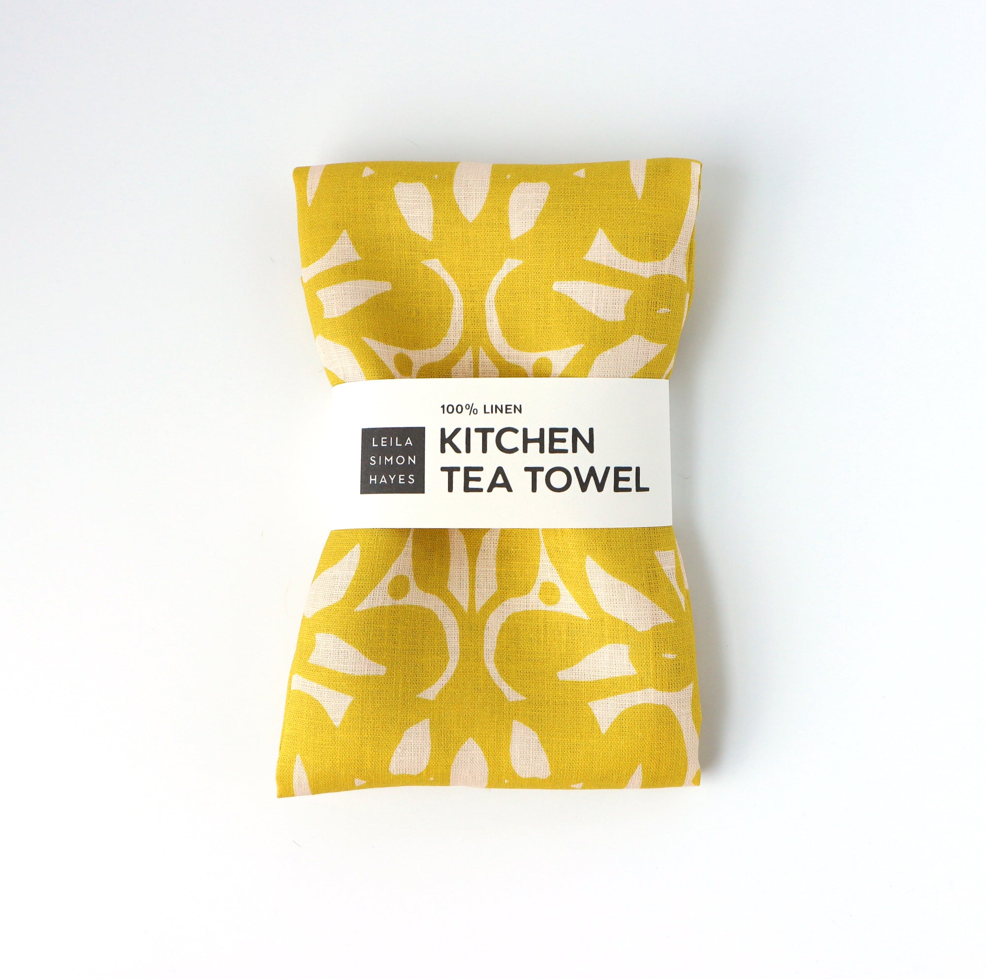 Yellow kitchen tea towel with light yellow patterns on a white background. Designed by artist Leila Simon Hayes.