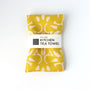 Yellow kitchen tea towel with light yellow patterns on a white background. Designed by artist Leila Simon Hayes.