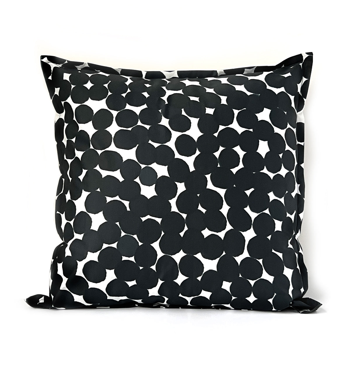 Black and white ink dots patterned across a decorative throw pillow on a white background.