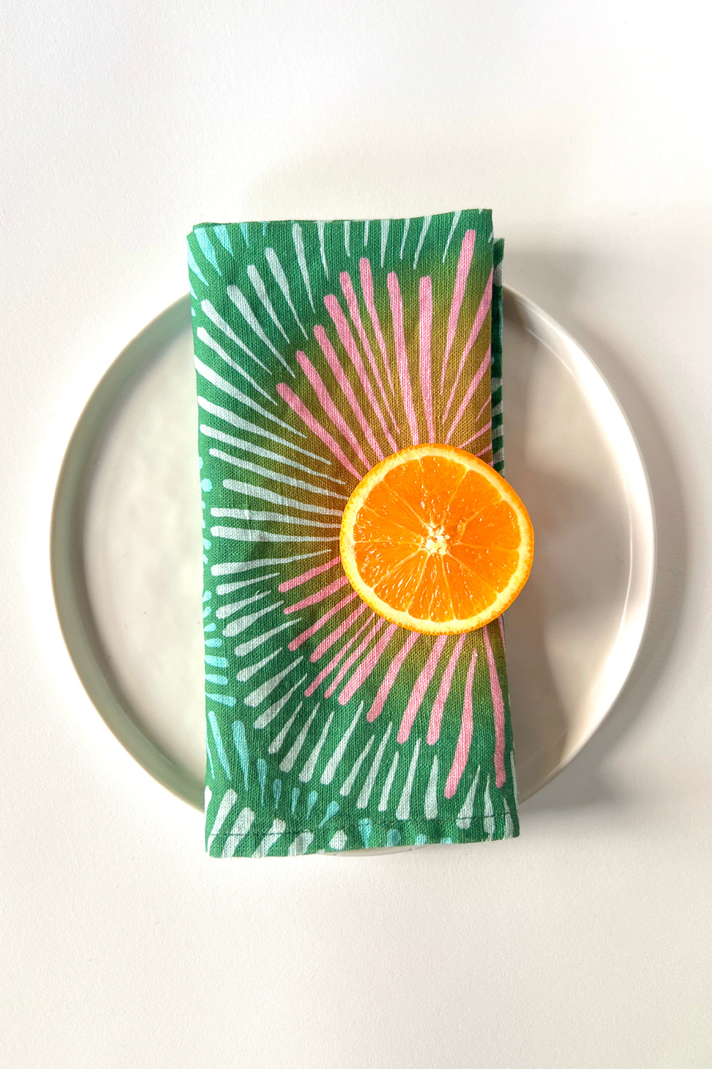Green and pink patterned dinner napkin designed by artist Leila Simon Hayes. 