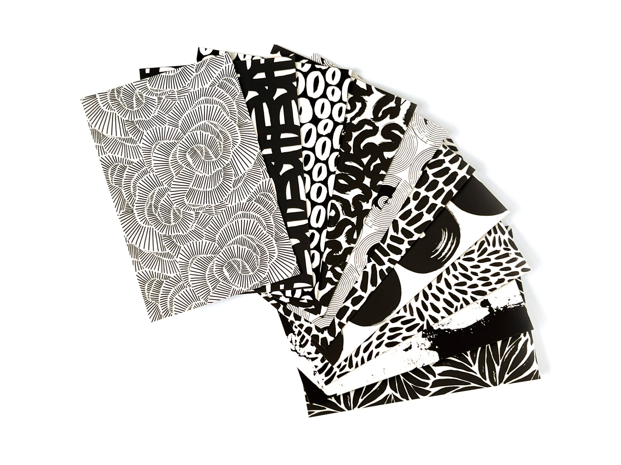 10 black and white postcards spread across a table with a white background. Designed by artist Leila Simon Hayes.