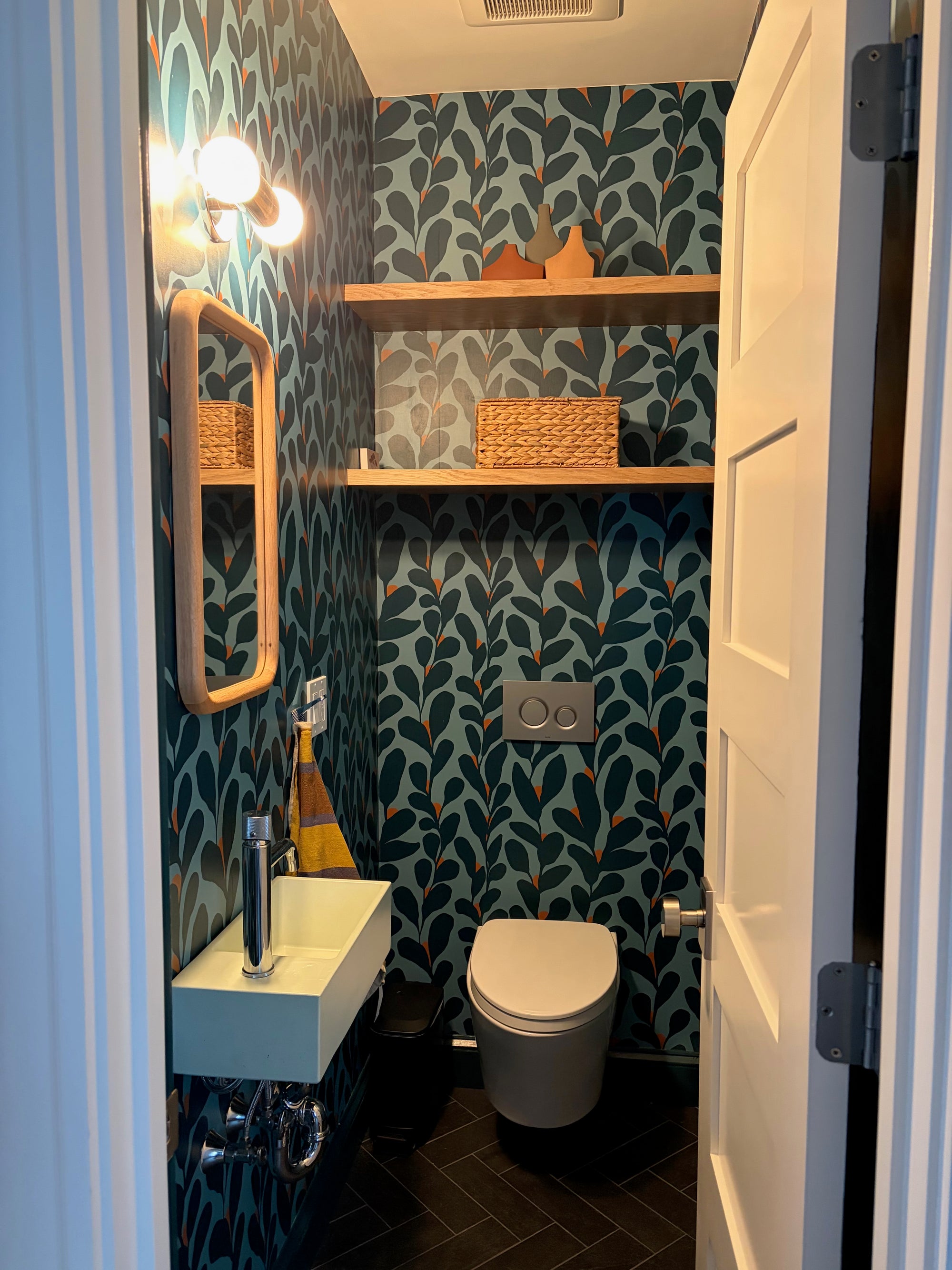 Bathroom, powder room, with blue floral patterned wallpaper, sink, and toilet. Designed by Leila Simon Hayes. 